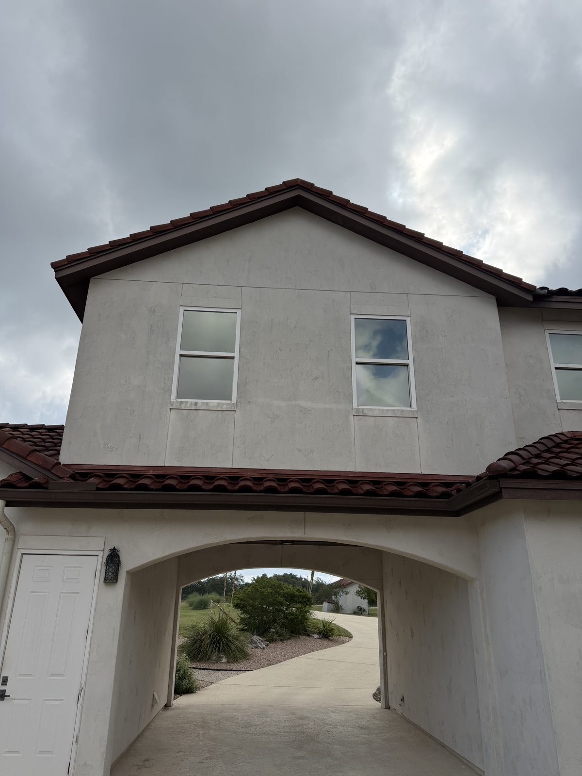 Stucco home exterior with dirt and organic staining before soft washing