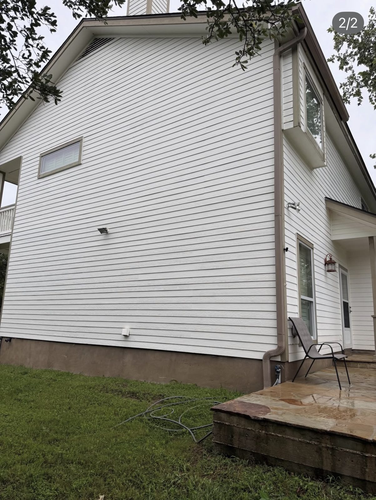 Bright white siding on a two-story home after house soft washing