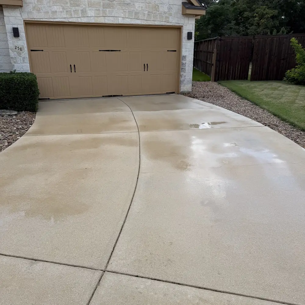 Same driveway restored to a bright, even finish after professional concrete cleaning