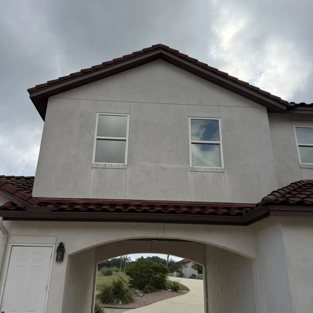 Stucco home exterior with dirt and organic staining before soft washing