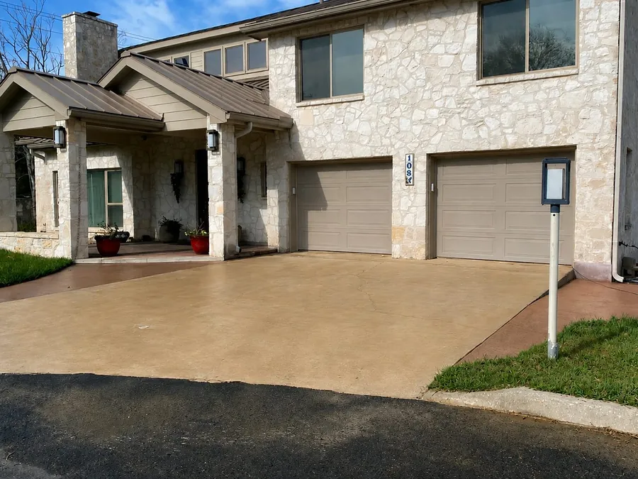 Bright, freshly pressure washed driveway at a stone home in Boerne TX